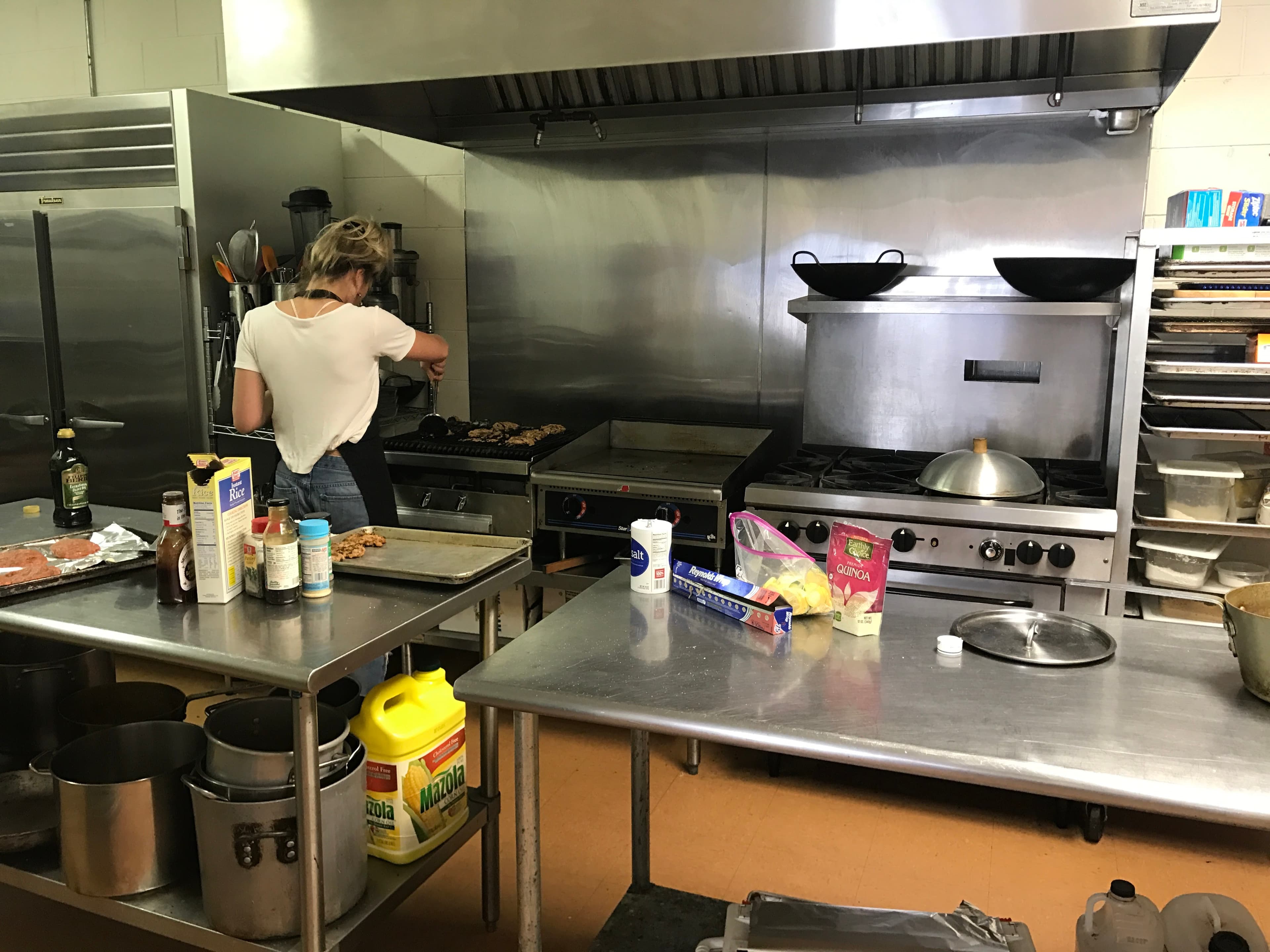 Allie cooking at the grill in the kitchen during Tough Cookies’ first months